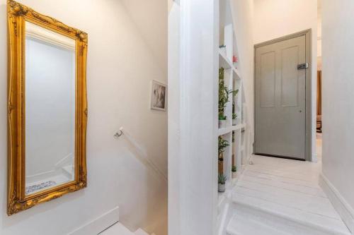a hallway with a mirror on the wall and a door at Spacious and modern London duplex apartment with garden in London