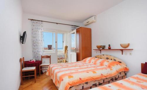 a bedroom with two beds and a desk and a window at Apartments Aurora Adriatica in Brist