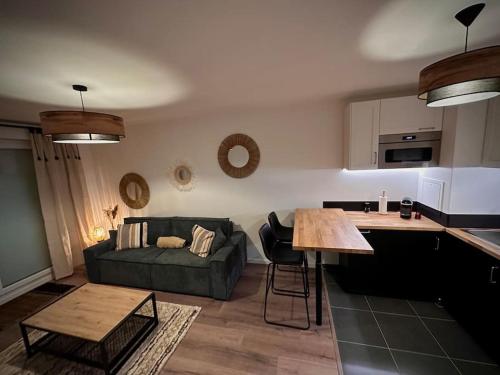 uma sala de estar com um sofá verde e uma mesa em Appartement cosy em Meaux