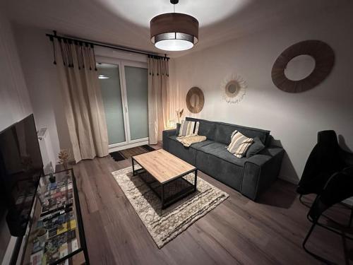 uma sala de estar com um sofá e uma mesa de centro em Appartement cosy em Meaux