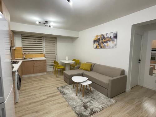 a living room with a couch and a kitchen at Yellow Apartment in Floreşti