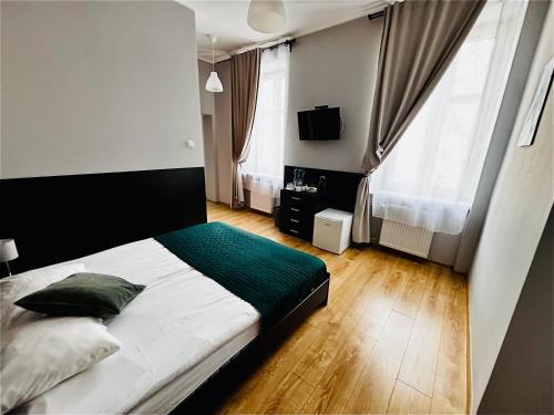 sypialnia z dużym białym łóżkiem i zielonym kocem w obiekcie BedRooms Piotrkowska 64 w Łodzi