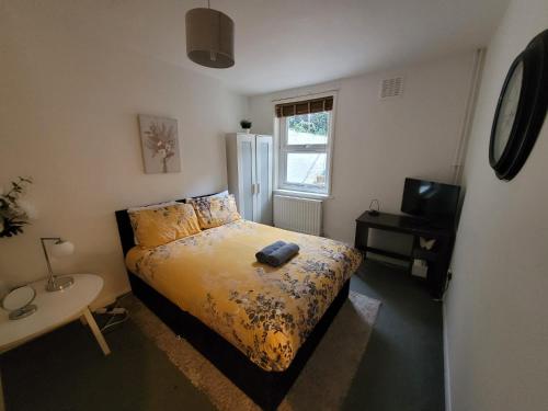 a bedroom with a bed and a desk and a television at 2 bed luxury flat in Lambeth in London