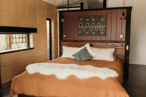 sypialnia z dużym łóżkiem z drewnianym zagłówkiem w obiekcie Mayan Luxe Villas w mieście Kin Kin