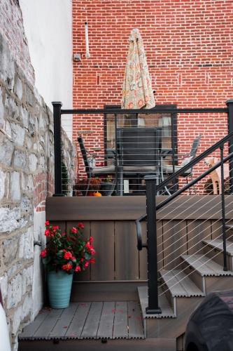 a balcony with a bench and flowers on a brick wall at Sweet Lancaster Apt. B in Lancaster
