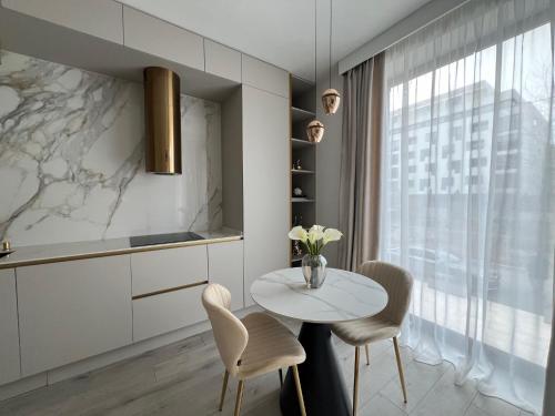 a kitchen with a table and chairs and a window at Harmony Property WIN HERASTRAU in Bucharest