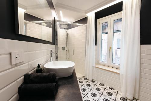 a bathroom with a white tub and a window at Dimora Palatina in Tivoli