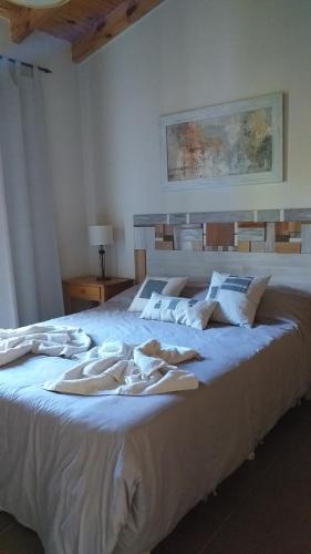 - un grand lit blanc avec des serviettes dans l'établissement Departamento "Avanti", à San Martín de los Andes