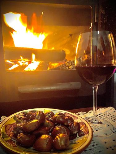 a glass of wine next to a plate of food at Lago da Garça Guesthouse in São Pedro do Sul