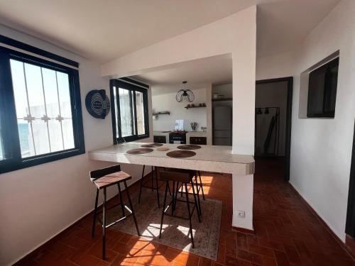 a kitchen with a counter and stools in a room at Le Cabaoui in Poponguine