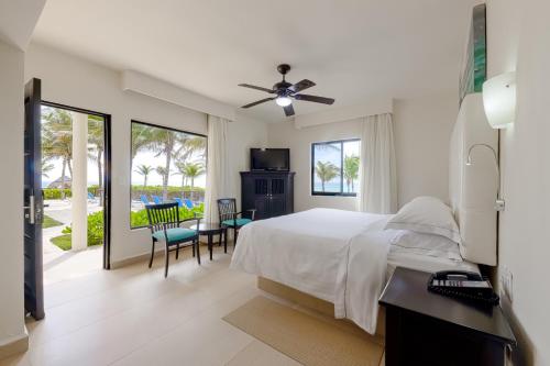 1 dormitorio con 1 cama, mesa y sillas en Allegro Playacar - All Inclusive Resort en Playa del Carmen