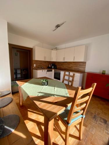 a kitchen with a wooden table and a table and chairs at Alpenchalet Basecamp Apartment 1 in Sankt Martin am Tennengebirge