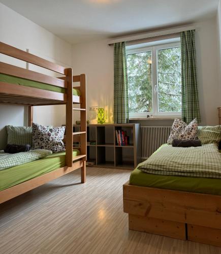 a bedroom with two bunk beds and a window at Alpenchalet Basecamp Apartment 1 in Sankt Martin am Tennengebirge