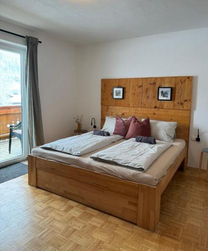 a bedroom with a large bed with a wooden headboard at Alpenchalet Basecamp Apartment 1 in Sankt Martin am Tennengebirge