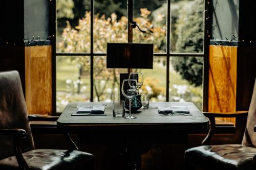 a table with a lamp in front of a window at Haweswater Hotel in Bampton