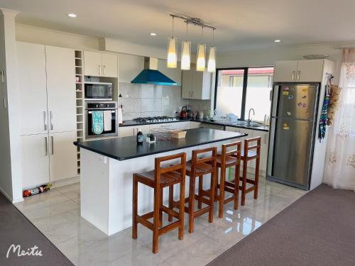 a kitchen with a large island with bar stools at Maungaraki View in Lower Hutt