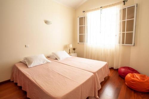 Un dormitorio con una cama grande y una ventana en Villa Margarida, en Ponta do Sol