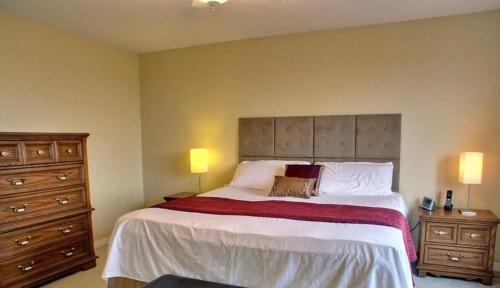 a bedroom with a large bed with two dressers and two lamps at HB Guest Home in Waterloo
