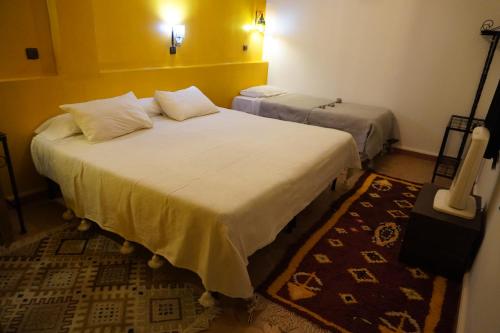 two beds in a hotel room withermottermott at La Kasbah Elkhorbat Muxu Berbere in Asrir