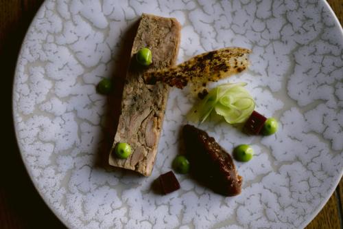 a white plate with a piece of bread and green olives at Haweswater Hotel in Bampton