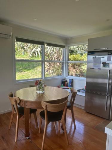 a kitchen with a table and a refrigerator at Rotorua Lakes House in Rotorua