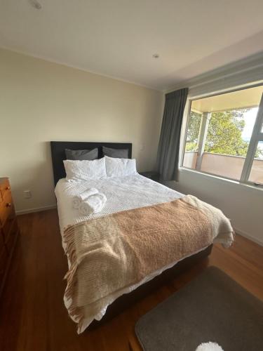 a bedroom with a large bed with a window at Rotorua Lakes Cottage in Rotorua