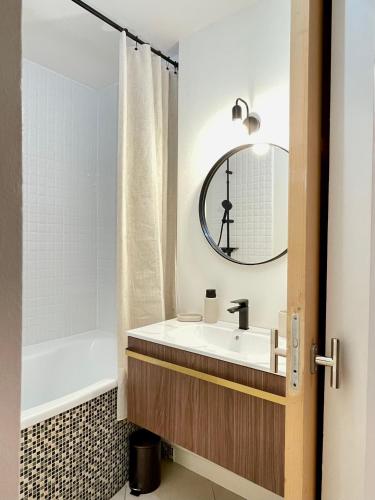 une salle de bain avec un lavabo, une baignoire et un miroir dans l'établissement Lovely 2 Bedrooms, calm, Paris Boulogne 6p, à Boulogne-Billancourt