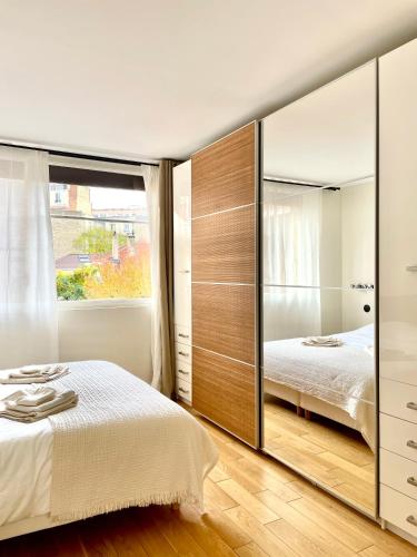 une chambre avec un grand miroir et un lit dans l'établissement Lovely 2 Bedrooms, calm, Paris Boulogne 6p, à Boulogne-Billancourt