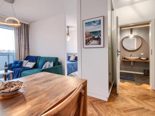 a living room with a blue couch and a table at Gdańsk Amber Suite with Parking by Rentujemy in Gdańsk