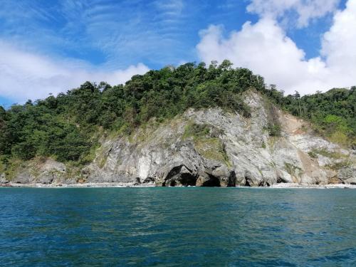 an island with a cave in the middle of the water at Mira Olas Cabins in Pavones