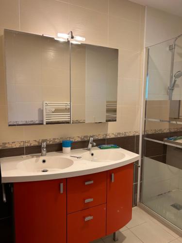 La salle de bains est pourvue de 2 lavabos et d'un grand miroir. dans l'établissement Villa moderne avec piscine dans impasse au calme, à Clapiers
