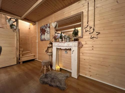 a room with a fireplace in a wooden wall at Ustronne Chatki - Ostoja nad Potokiem in Ustroń