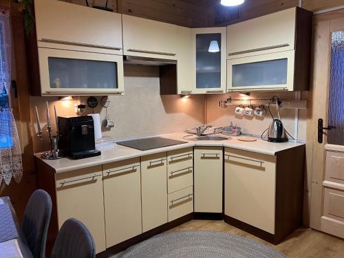 a small kitchen with white cabinets and a sink at Ustronne Chatki - Ostoja nad Potokiem in Ustroń