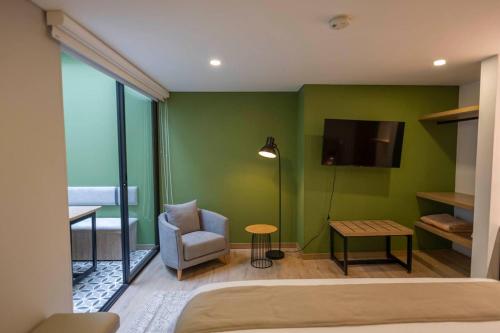 a bedroom with a bed and a tv and a chair at Siete Balcones Hotel Coworking in Pasto