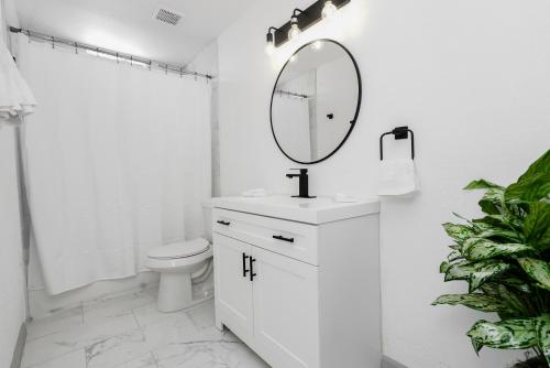 a white bathroom with a sink and a mirror at Staycasion @ Galveston in Galveston