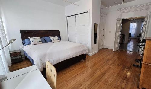um quarto com uma cama grande e piso em madeira em Sylish 1 Bedroom Apartment in NYC! em Nova York