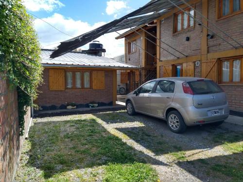 ein vor einem Haus geparktes Auto in der Unterkunft Nahucar in El Bolsón