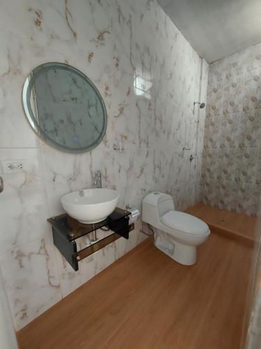 a bathroom with a sink and a toilet and a mirror at Departamento de playa amoblado in Cerro Azul