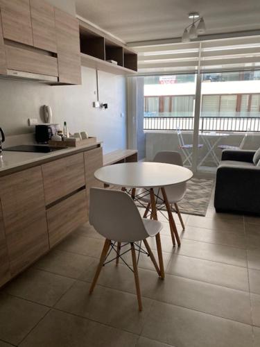 een keuken met een tafel en stoelen in een kamer bij Apart Center Temuco in Temuco
