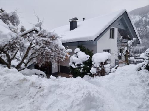 a snow covered house with a pile of snow at Comfy mountain nest in Mojstrana