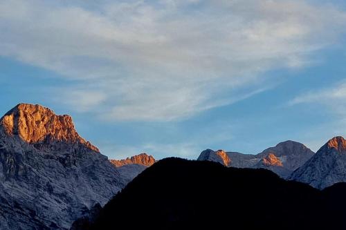 a view of mountains with the sun shining on them at Comfy mountain nest in Mojstrana