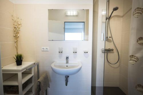W łazience znajduje się umywalka i prysznic. w obiekcie Frische-Brise-05-06 w mieście Cuxhaven