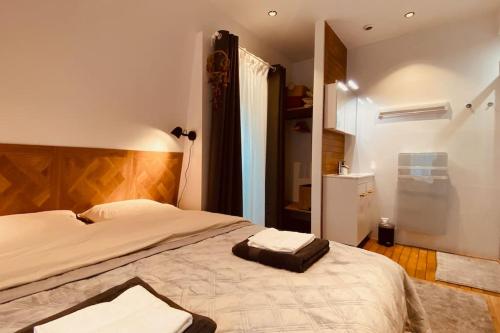 um quarto com uma cama grande e uma cabeceira em madeira em Superbe appartement proche de Paris em Saint-Maurice