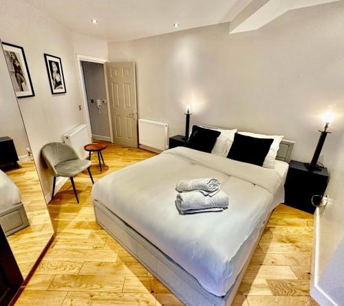 1 dormitorio con 1 cama blanca grande y 1 silla en Doric apartment en Londres