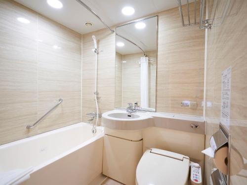 a bathroom with a toilet and a sink and a bath tub at Daiwa Roynet Hotel Hiroshima in Hiroshima