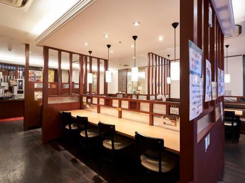 a dining room with a long table and chairs at Daiwa Roynet Hotel Hiroshima in Hiroshima