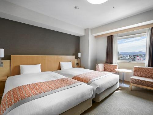 a hotel room with a large bed and a window at Daiwa Roynet Hotel Hiroshima in Hiroshima