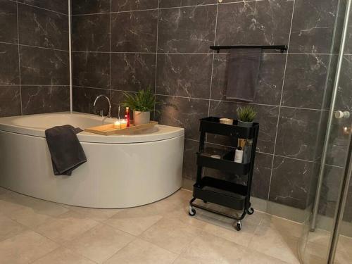 ein Bad mit einer Badewanne, einer Dusche und einem Waschbecken in der Unterkunft 54:an - flott rekkehus med gangavstand til sentrum in Røros