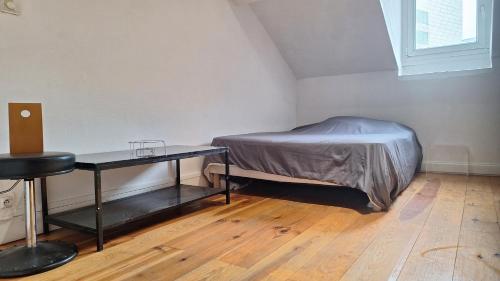 a small bedroom with a bed and a table at Studio cosy Gare in Grenoble
