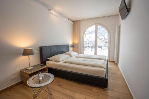 a bedroom with a bed and a large window at TEMPFER Apartments & Rooms with new WELLNESS in Rateče